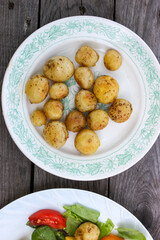 Round new potatoes fried to Golden brown with tomatoes, herbs and lettuce