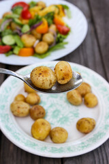 Round new potatoes fried to Golden brown with tomatoes, herbs and lettuce