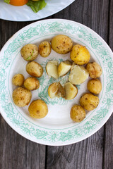 Round new potatoes fried to Golden brown with tomatoes, herbs and lettuce