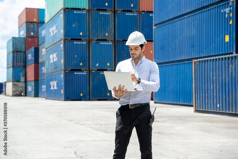 Poster businessman standing and using walkie talkie checking stock into container for loading in shipping p