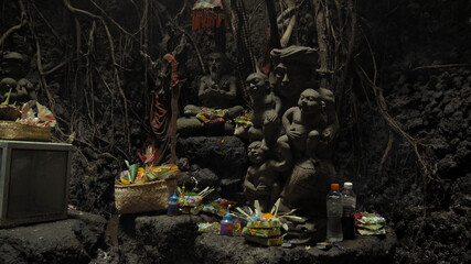 Religious place for rites with ancient statues of people in a dark cave with strong shadows