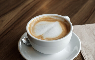 closed-up of hot drink coffee in white mug on brown wood table