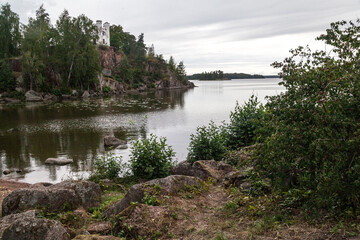 Autumn Monrepos Park with small vintage castle on granite rock near big lake