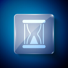 White Old hourglass with flowing sand icon isolated on blue background. Sand clock sign. Business and time management concept. Square glass panels. Vector.