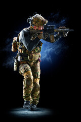 Army soldier in Protective Combat Uniform holding Special Operations Forces Combat Assault Rifle on...
