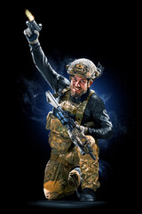 Army soldier in Protective Combat Uniform holding Special Operations Forces Combat Assault Rifle on...