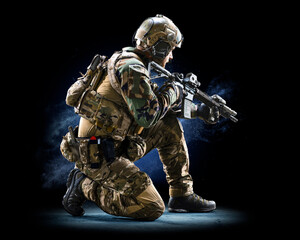 Army soldier in Protective Combat Uniform holding Special Operations Forces Combat Assault Rifle on...