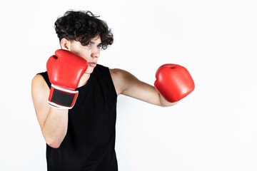 Handsome athletic teenager is training in boxing gloves on a white background. The guy dreams of a boxing career and training every day