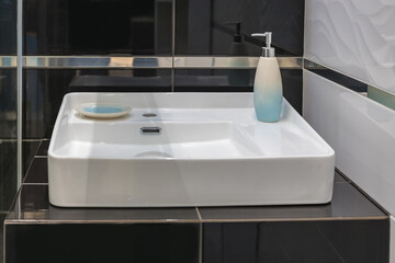 Modern design bathroom sink in a modern residential building or hotel. Modern white bathroom sink with a tap.