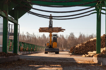 Industrial loader transports logs at a sawmill