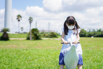 コロナウイルスに気をつけながら公園で遊ぶ子供