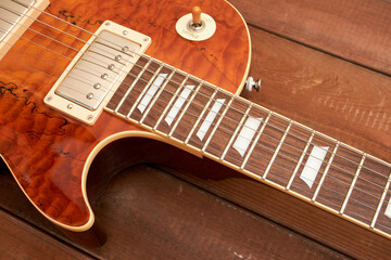 orange colored LP type guitar on dark table