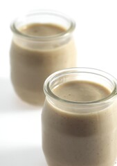 Glasses of Hazelnut Cream against White Background