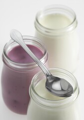 Glasses of Natural and Raspberry Yoghurt against White Background