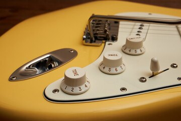 Butter colored Strat guitar on dark table