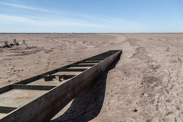 Rusty iron beam in the middle of a sandy wasteland