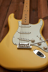 Butter colored Strat guitar on dark table