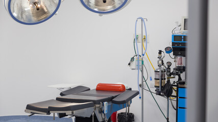 hospital room with a black gurney, medical instruments and lamps, white background