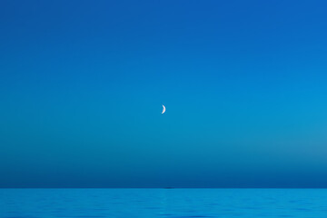 Blue Night Sky With A Crescent Moon Over The Sea - 370596610