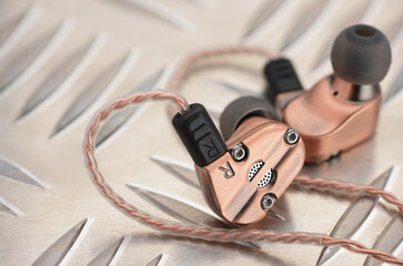 Hybrid dynamic driver balanced armature earbuds on the metal plate.