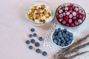 Bowl of oatmeal, fresh blueberry, cold cherry and almond nuts for breakfast. Healthy vegetarian food. Top view.
