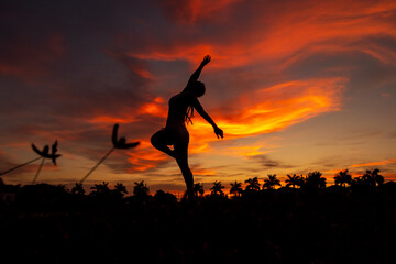 Silhouette of a woman doing yoga exercises at sunset