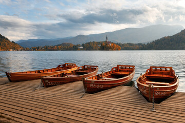 Amazing autumn view of Bled lake in Julian Alps, Slovenia. Wooden boat on city pier. Pilgrimage...