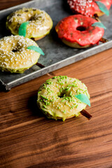 Doughnuts or donuts. Classic American favorite, apple cider donuts iced with maple syrup flavored butter cream frosting and topped with gold leaf sprinkles and decorations.