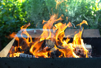 Obraz premium Close up of fire on chargrill. Dry sticks smoulder. Concept of cooking on grill.