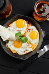 Top view of frying pan with three fried eggs