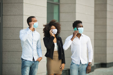 handsome african young men wearing medical face masks with mobile phones