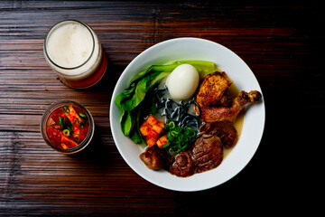 Ramen noodles. Japanese classic soup, with noodles, broth, pork, chicken, tofu, scallions, mushrooms, eggs and red pepper sauce. Copy space.