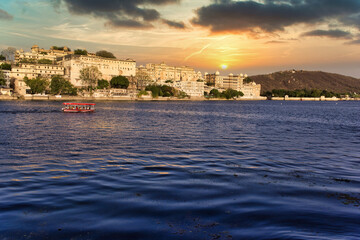 Fototapeta premium Udaipur, India: The scenic view of Ambrai Ghat and Lake Pichola against dramatic sunset located in Rajasthan state