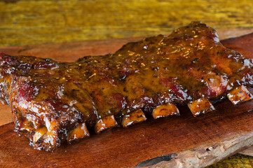 Obraz na płótnie Canvas Pork ribs, barbecue style. Classic Traditional Texas Smokehouse favorite menu item: Baby Back pork ribs. Slow cooked in seasoned smoker over mesquite wood chips covered in homemade bbq sauce. 