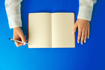 To do list. Top view of female hands writing in notebook