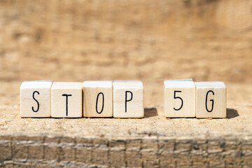 Wooden cubes with the word STOP 5G on wooden background, technolegy mobile concept