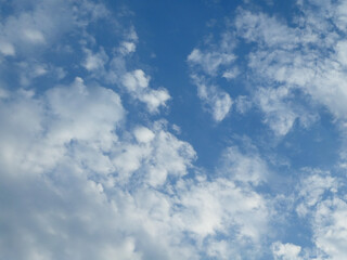 The blue cloudy sky with white clouds background and texture