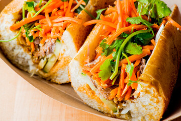 Bánh mì or banh mi, Vietnamese word for bread. Traditional classic Vietnamese cuisine. Baguette with pate, pulled pork, jalapenos, cilantro, carrots cucumbers and spicy sauce.
