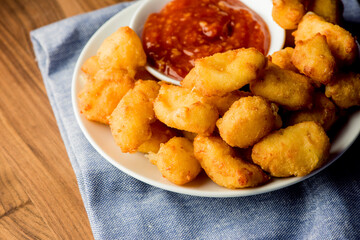 Breakfast sandwich. Bacon, fried egg, lettuce, tomato and onion on a bun being smashed by a waitresses hand. Action shot.