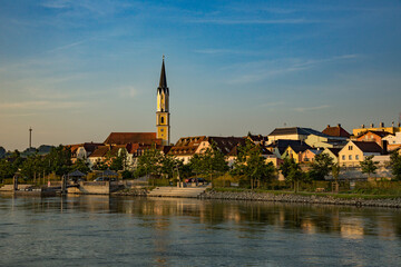 Fototapeta na wymiar Danube River and a church with a clock tower near Passau Germany