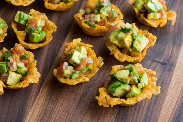 Spicy Guacamole served in crispy taco shells with salsas, cilantro and lime. Avocados diced and mixed with lemon and lime juices. Classic Tex-Mex, Mexican or American restaurant appetizer favorite.