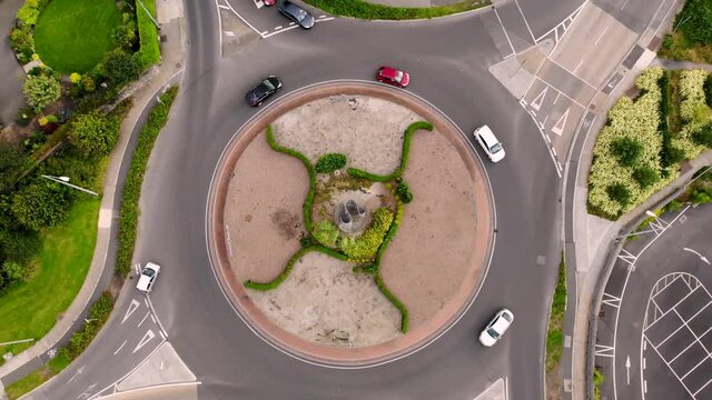 Roundabout traffic aerial fly up birds eye view drone shot. Usual afternoon traffic during working day, Balbriggan, Ireland