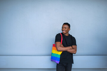 Young black man standing against white wall background, black lives matter concept.