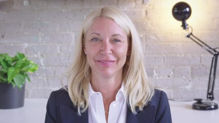 Camera POV of a young caucasian woman having an online conversation in a remote video conference call, waving goodbye