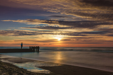 stojący samotnie chłopiec na molo w Kołobrzegu plaża zachodnia