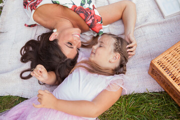 Top view shot of a mother and daughter laughing, having fun at the picnic outdoors