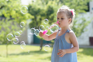 little girl blowing soap bubbles