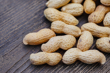 peanut grain in peel on wooden background