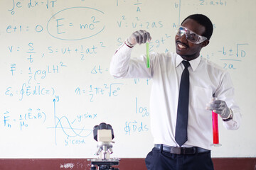 Science african teacher standing in front of blackboard teaching student in classroom
