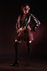 Frau in bunter Kleidung mit bunter Sonnenbrille im Gesicht vor lila Hintergrund